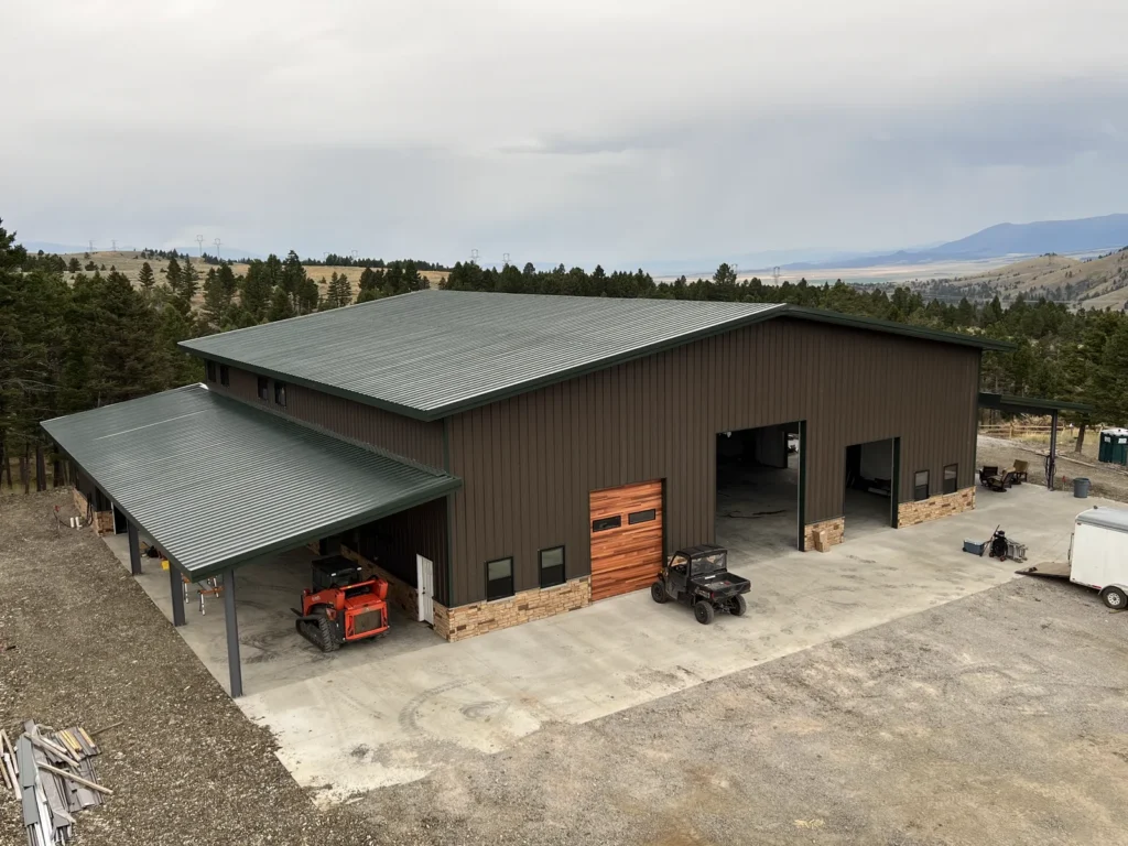 80x80 gable-roof steel workshop with covered lean-to porch and stone wainscot in Townsend, MT